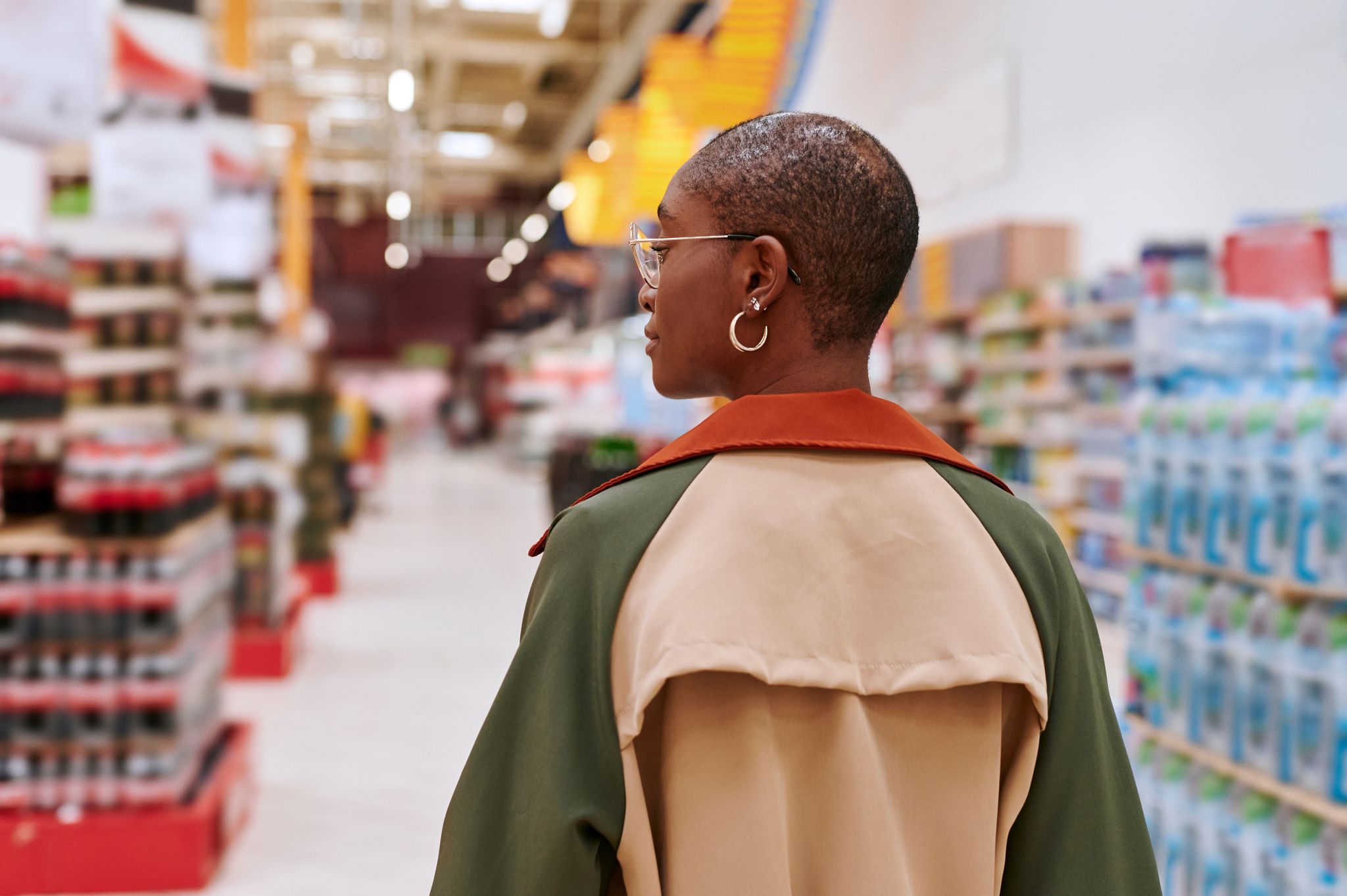 Girl walking in a supermarket aisle.